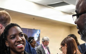 Personnel conduct educational outreach with students