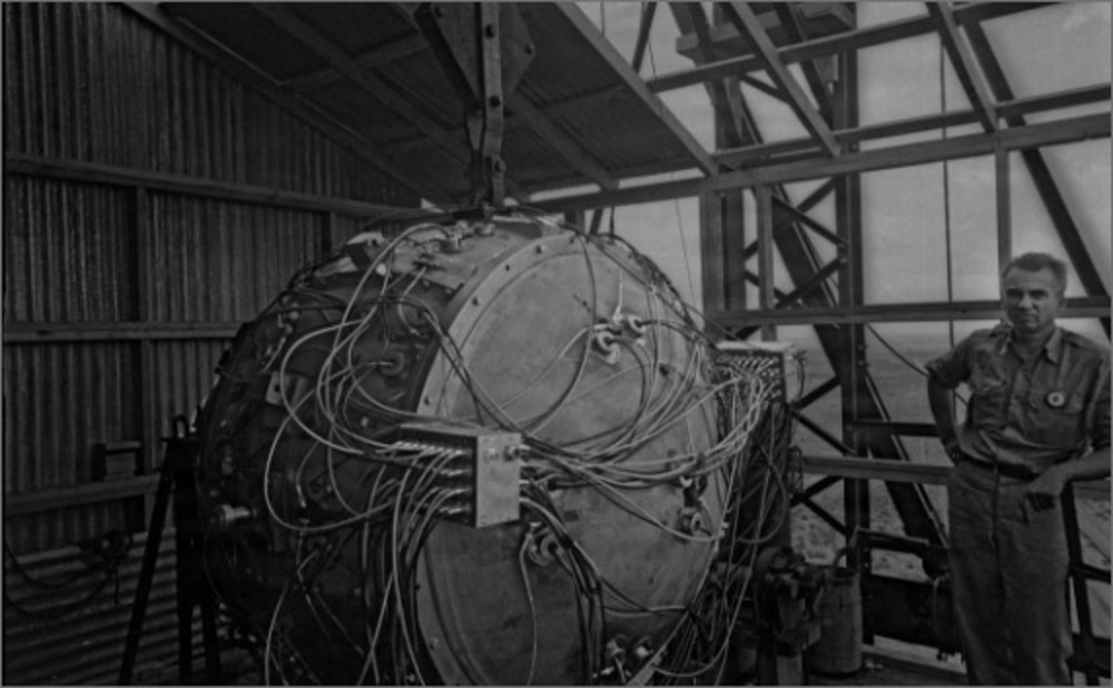 An engineer works near the first atomic bomb in this historical photograph