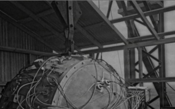 An engineer works near the first atomic bomb in this historical photograph