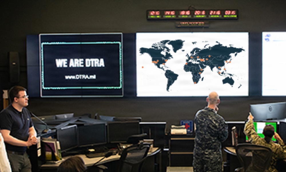 Defense Threat Reduction Agency personnel monitor multiple screens in an operations center. Defense Threat Reduction Agency personnel monitor multiple screens in an operations center.