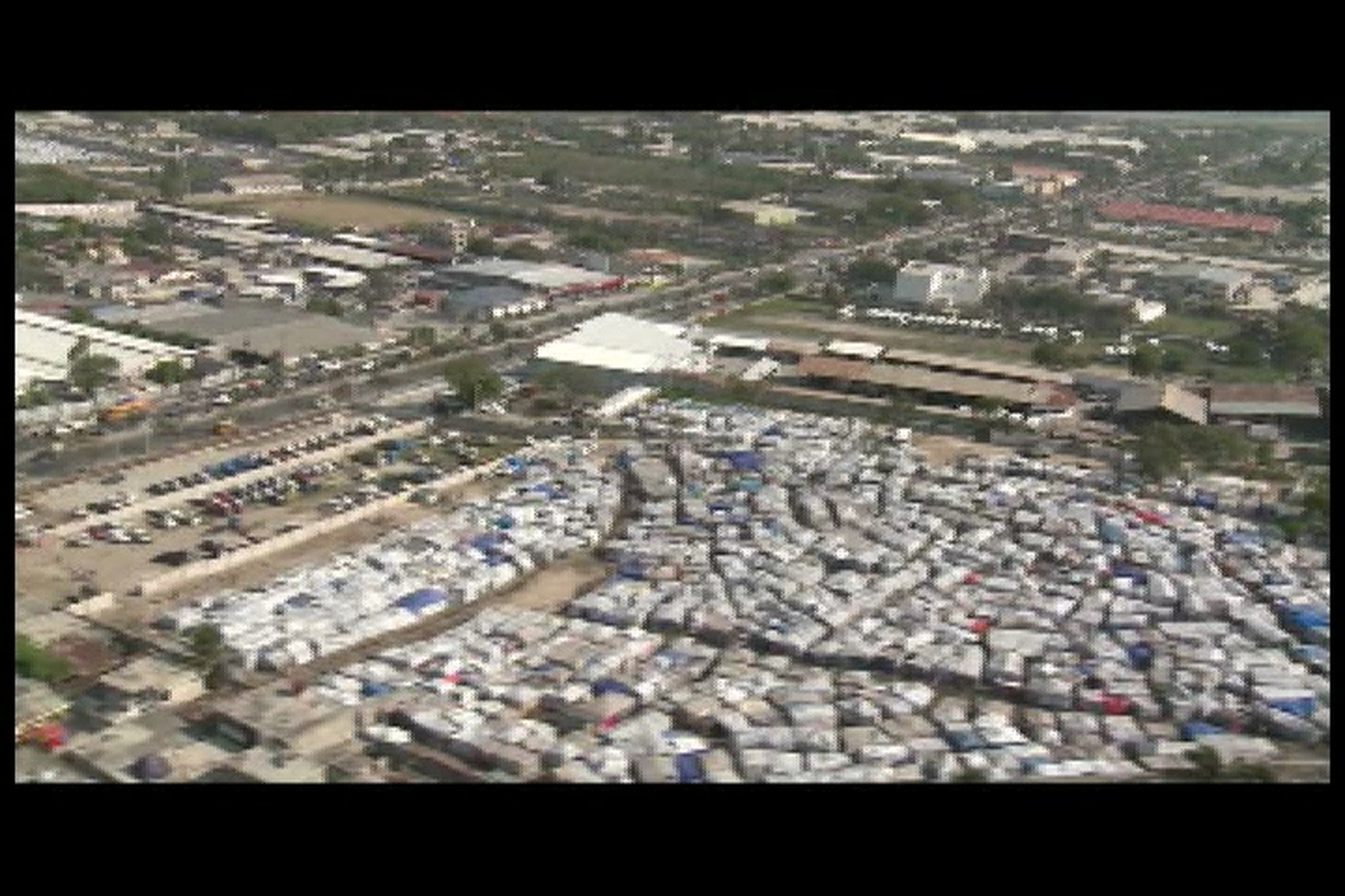 B-roll of aerial shots over the city of Port-au-Prince, Haiti, two months after earthquake. Scenes include the city of Port-au-Prince, Sea Port, Hotel Montana, displaced Haitians camp at Petionville Club Golf Course,  and various other camp sites around the city. Produced by Juan Torres-Diaz. Part 1 of 2. Also available in high definition.