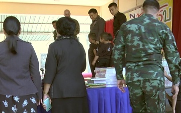 Marine Air Group 12 and the Royal Thai Army present books and other educational material to school children.