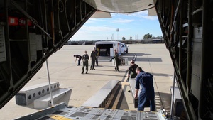 Coast Guard Pacific Strike Team members and an Air Station Barbers point aircrew load decontamination gear for RIMPAC exercise