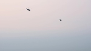 U.S. Navy UH-1N Twin Huey helicopters depart flight line