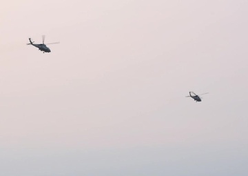 U.S. Navy UH-1N Twin Huey helicopters depart flight line