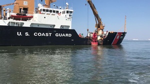 Crewmembers aboard the Coast Guard Cutter Willow reposition a buoy