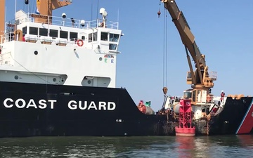 Crewmembers aboard the Coast Guard Cutter Willow reposition a buoy