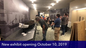 Museum staff members celebrate after a macro-artifact is installed
