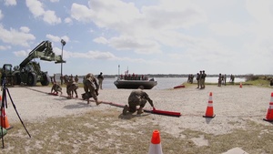 U.S Marines and Sailors unload containers off the improved Navy lighterage system at MPFEX20