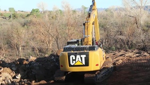 A worker removes material to prep a panel installation site.