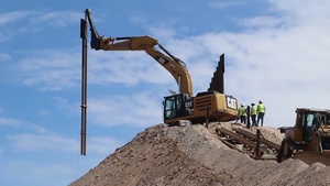 Installing barrier panels on a hillside