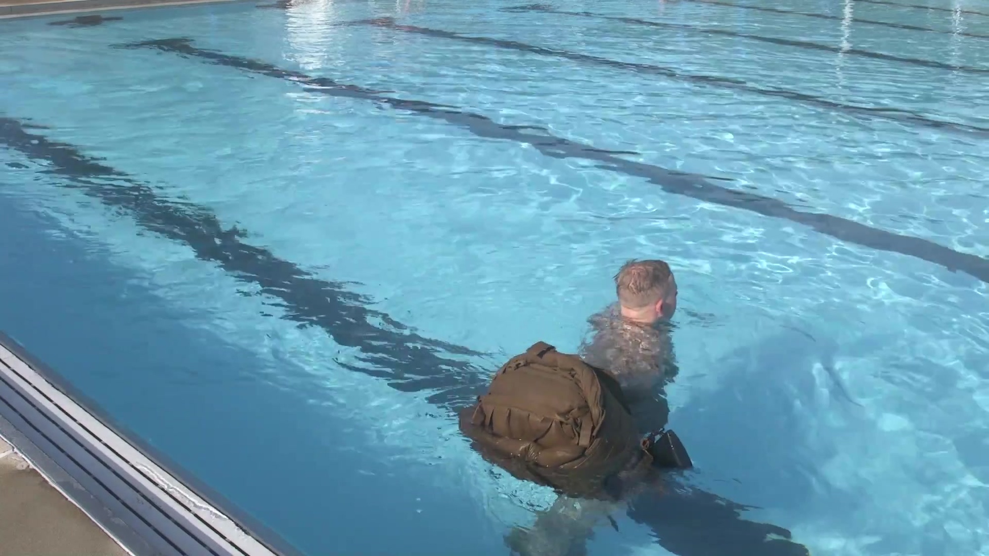 Given an aquatic environment, using a properly waterproofed pack with a full combat load, while wearing combat uniform. Enter the water, gain control of pack walk 25 meters in shallow water pushing or towing the gear.
The videos are part of a how-to series for completion of the exit skill events in each level of the Marine Corps Water Survival Program (MCWSP). Video 4 of 5.