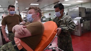 U.S. Sailors practice using a Reeves sleeve stretcher aboard the Military Sealift Command hospital ship USNS Comfort (T-AH 20)