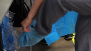 USPHS Personnel aid in the donning of PPE