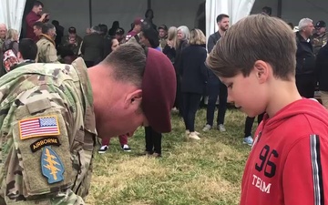82nd Airborne Division Solider offers patch to French boy