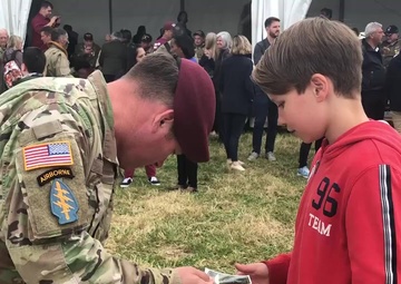 82nd Airborne Division Solider offers patch to French boy