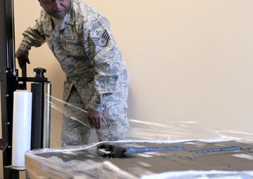 116th Comm Squadron personel wraps laptops for DLA disposition