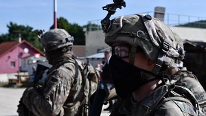 Soldiers patrol a village during Saber Junction 20