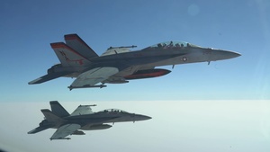 A U.S. Air Force KC-135 Stratotanker refuels U.S. Navy F-18F Super Hornets