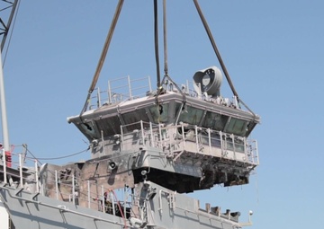 Salvage contractors remove pieces of USS Bonhomme Richard superstructure to ready the ship for towing