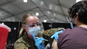 A Service Member administers the 10,000th COVID-19 Vaccine at the St. Paul, Minnesota Community Vaccination Center.