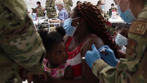 Senior Airman Anye helps vaccinate his wife and mother-in-law at the Greenbelt Metro CVC