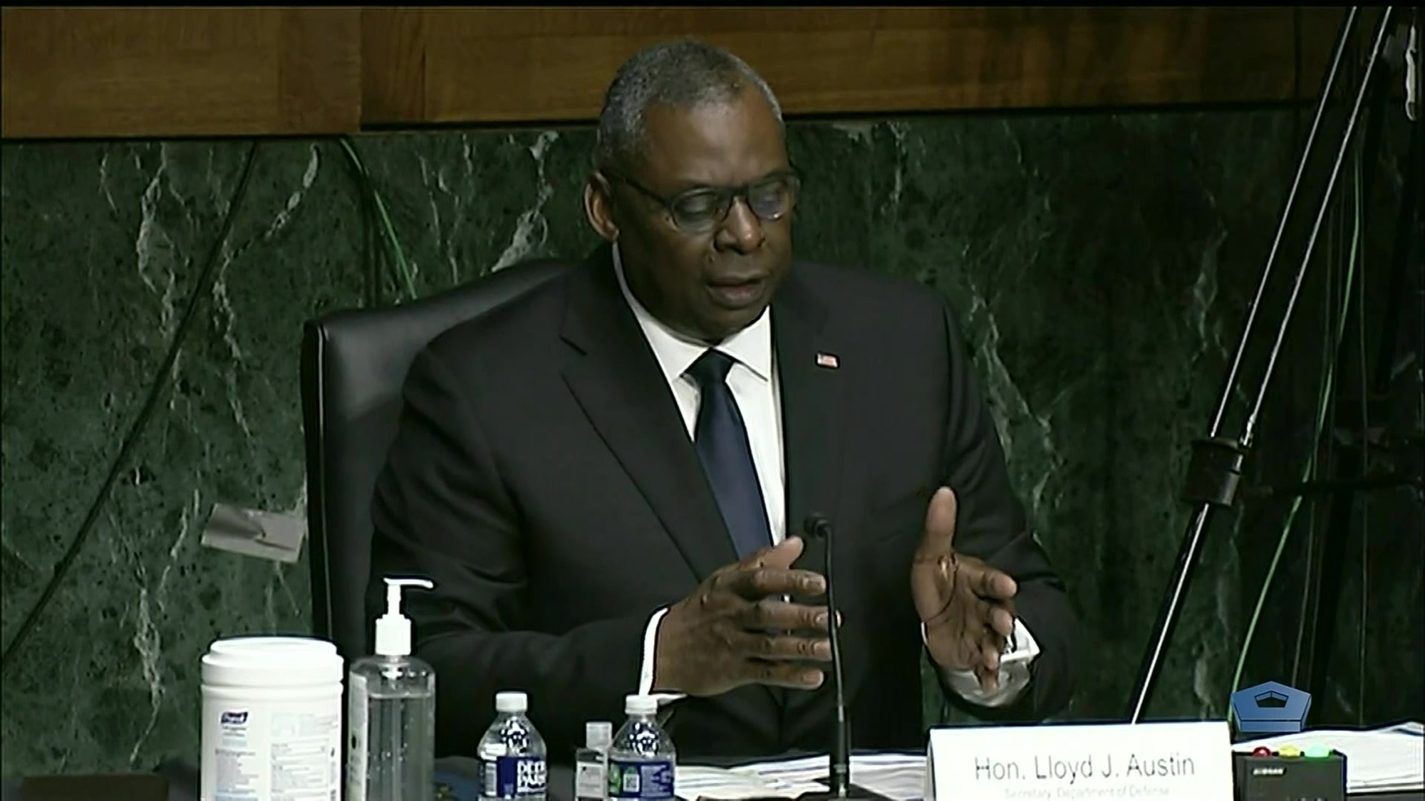 Secretary of Defense Lloyd J. Austin III speaks at a table.