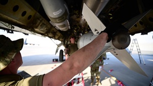 5th Expeditionary Munitions Squadron load bombs onto a B-52 Stratofortress