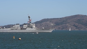U.S. Navy and Coast Guard ships transit under the Golden Gate Bridge