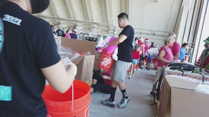 Volunteers pack donated goods into airdrop bundles during the 70th annual Operation Christmas Drop