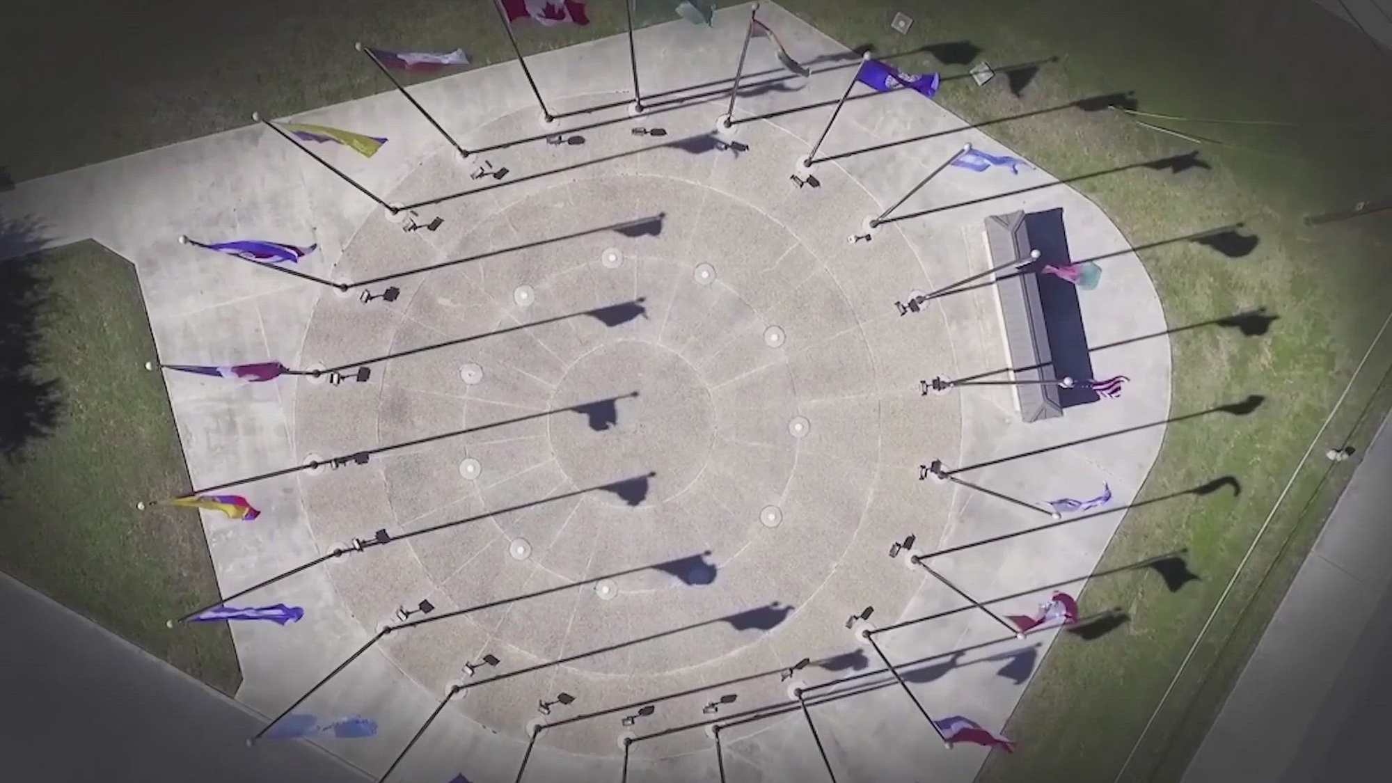 Overhead view of flags in a circular display outdoors. 