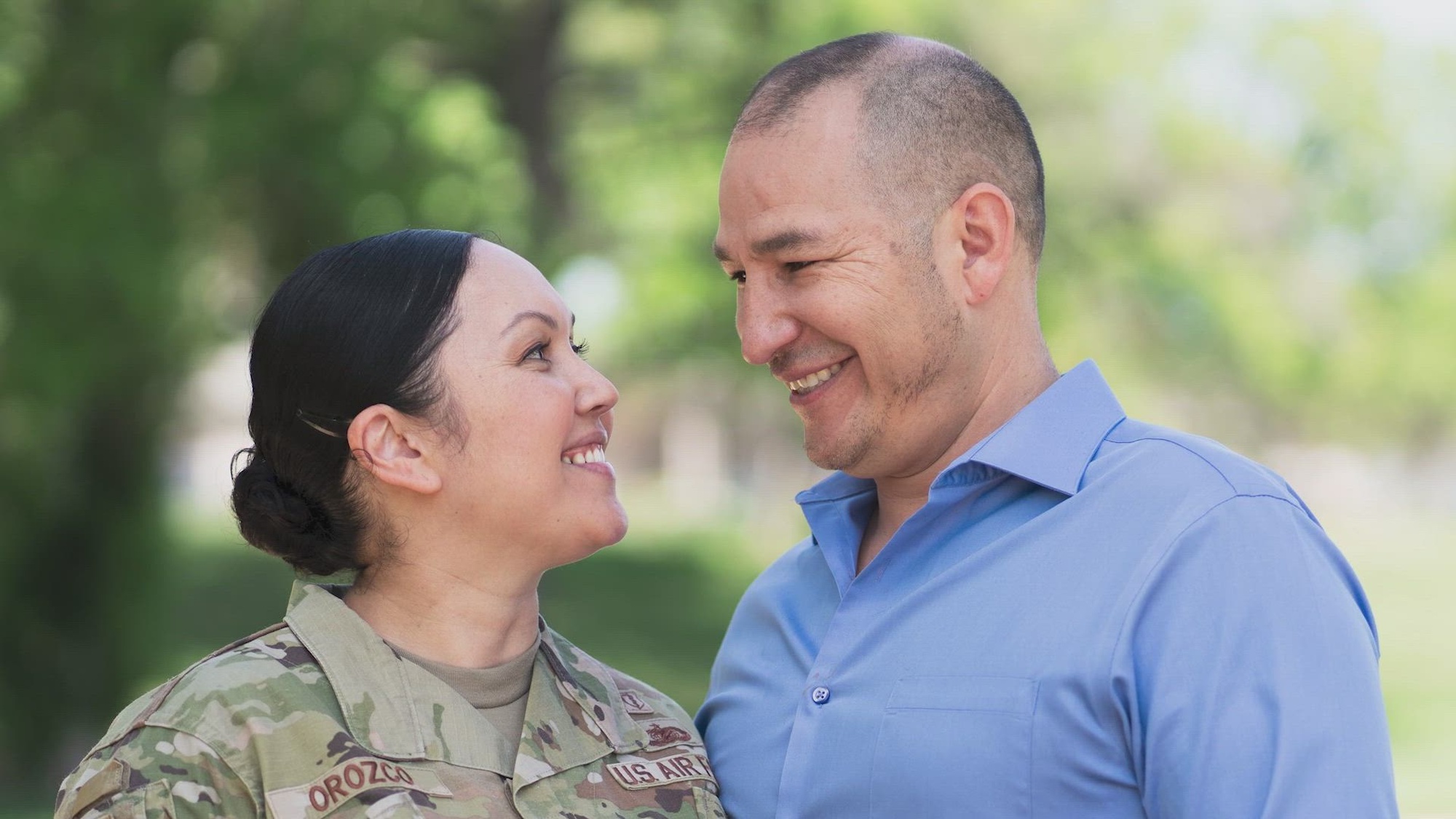 Photo of a smiling woman in military uniform and a smiling man in a blue shirt. 