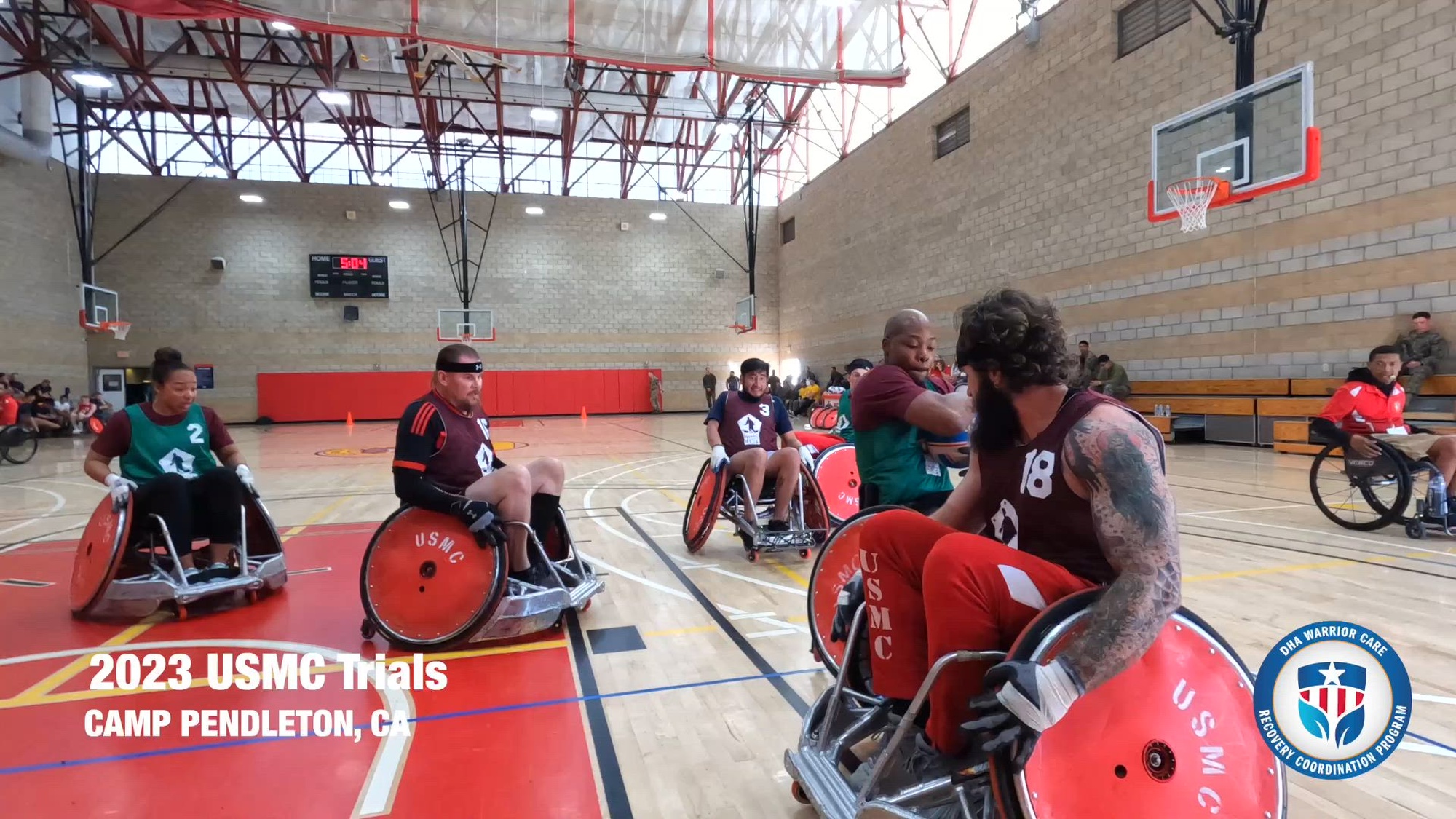 Athletes play wheelchair basketball on an indoor court. 