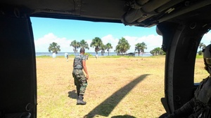 Multinational service members jump from UH-60