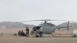 Marines and Sailors conduct a ground refuel on an MQ-8C Fire Scout.
