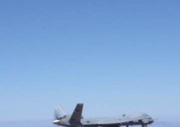 MQ-9 flying, firing Hellfire missiles