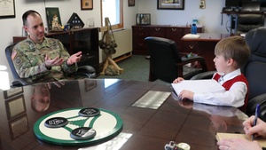 6-year-old confers with Fort McCoy Garrison commander for social studies project