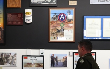 Battalions of 4th Combat Aviation Brigade present their mural displays in the Heritage Room to Maj. Gen. David Doyle and 4th Infinity Division