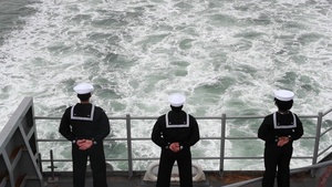 USS Tripoli sailors man the rails for the parade of ships
