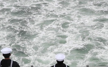 USS Tripoli sailors man the rails for the parade of ships