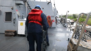 Sailors aboard the USS John Finn conduct a sea and anchor detail in Apra Harbor, Guam
