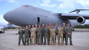 U.S. Air Force, Royal Australian Air Force and Royal New Zealand Air Force aeromedical evacuation members prepare to board a U.S. Air Force C-5 Super Galaxy aircraft