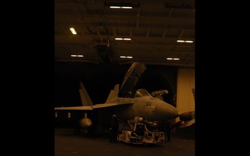 Abraham Lincoln Sailors m¬ove aircraft in the hangar bay