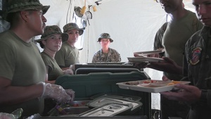 U.S. Marine food service specialists with 1st Marine Aircraft Wing serve chow on Ie Shima, Japan