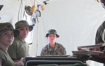 U.S. Marine food service specialists with 1st Marine Aircraft Wing serve chow on Ie Shima, Japan