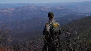 Border Patrol agent patrols mountainous area by vehicle and on foot