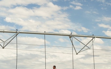 Farmer walks by irrigation pivot