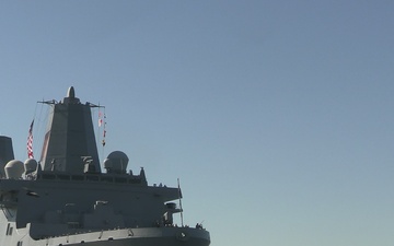 U.S. Marine and Sailor man the rails aboard the USS Arlington (LPD-24)