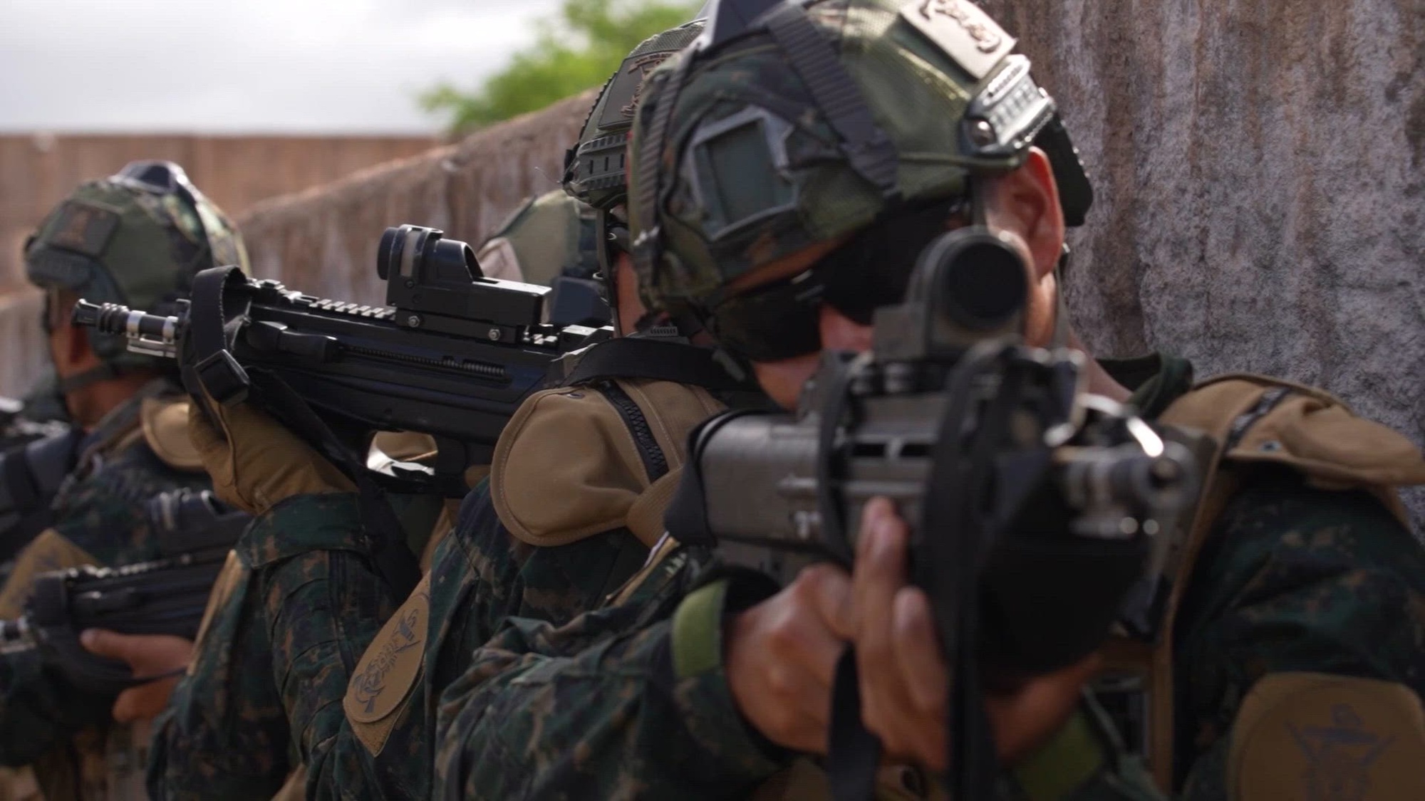 Service members conduct training exercises in a tropical location. 