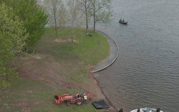 Volunteers and U.S. Army Corps of Engineers staff remove debris from the shoreline of Raystown Lake